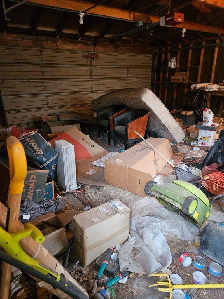 Hoarding cleanup before photo - garage filled with boxes and debris
